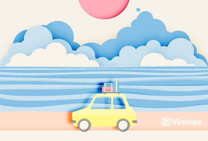 An image made of paper showing a yellow car with luggage strapped to its roof driving by the beach and white clouds coming in from the ocean in the background.