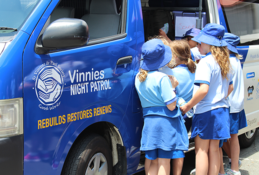 Primary School students visiting and learning about the Night Patrol team near the van.