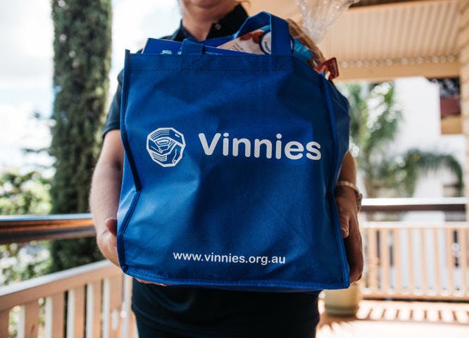 Vinnies Volunteer holding Vinnies donation hamper