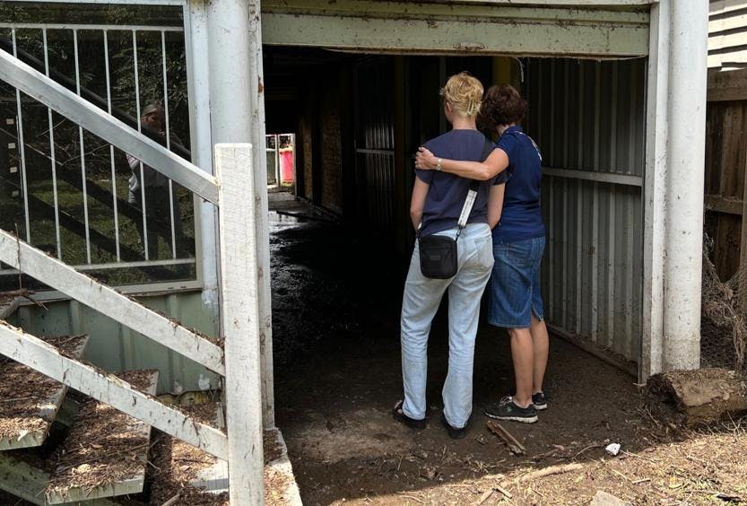 Vinnies volunteer consoling companion standing in flooded home