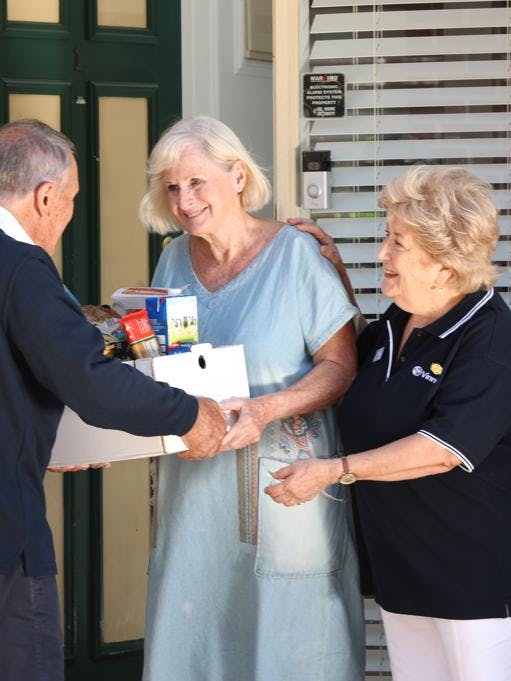 Elderly woman receiving help from some Vinnies Volunteers