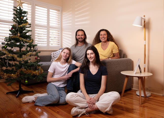 Vinnies companion family sitting in living room with Christmas tree