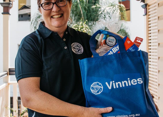 Vinnies volunteer holding bag of donations