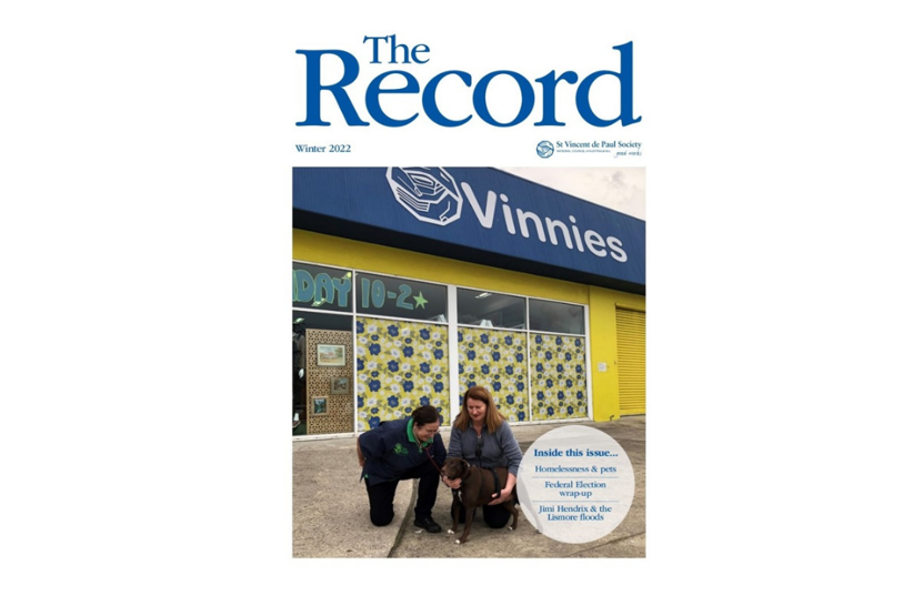 Cover of The Record showing title and edition info and a picture of 2 people with a dog in front of a Vinnies store.
