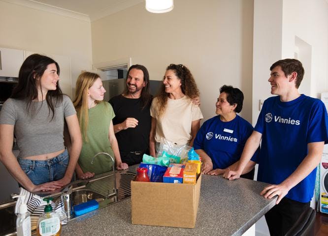 Family receiving food hamper from Vinnies volunteers