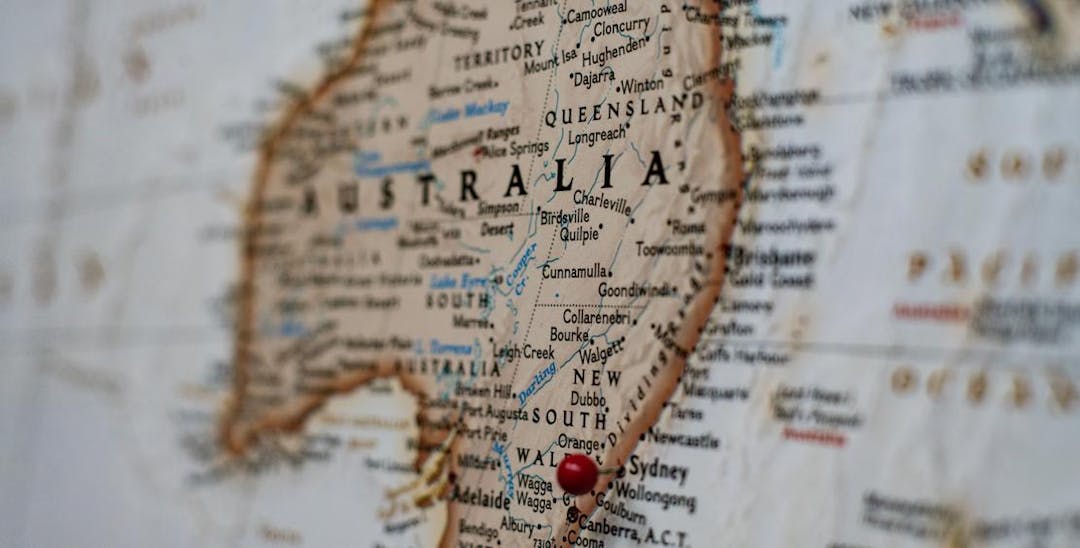 A photo of a map of Australia, with a red pin marking Sydney.