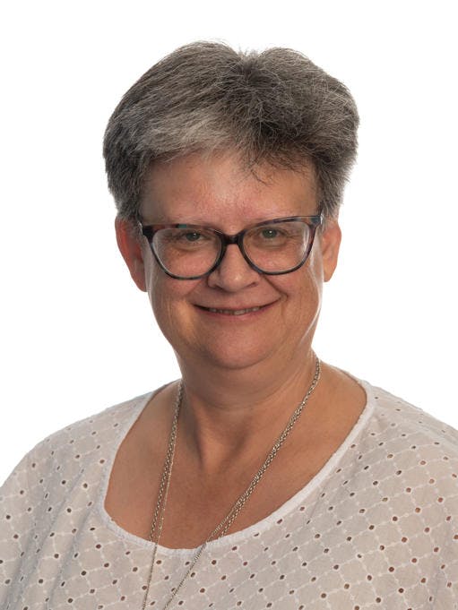 Headshot of Sr Teresa Haywood DC who is wearing a white shirt and long silver necklace 