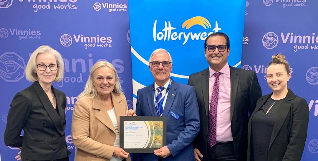 A photo of Community Services Minister Sabine Winton handing over the Lotterywest cheque to Vinnies WA. In the photo are 3 women and 2 men and they are all smiling at the camera.