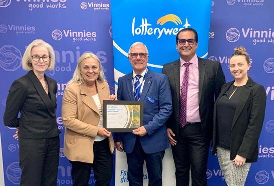 A photo of Community Services Minister Sabine Winton handing over the Lotterywest cheque to Vinnies WA. In the photo are 3 women and 2 men and they are all smiling at the camera.