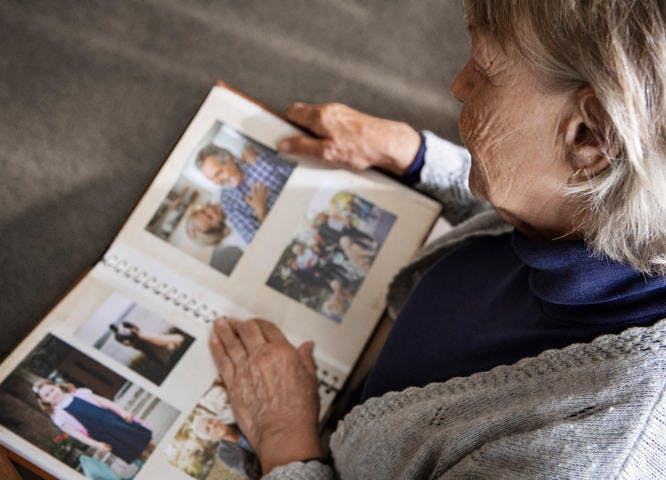 Elderly woman reflecting with photo album
